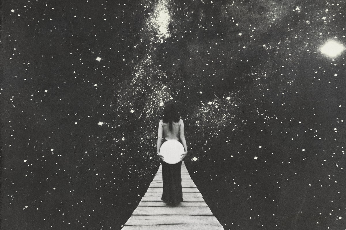 A woman gazes into a star-filled cosmic sky while standing at a pathway of light